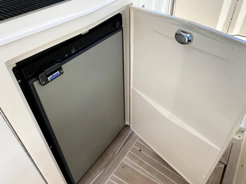 Slide: The Image of Azimut Atlantis Verve Outboard 2014 boat interior with open cabinet and mini fridge. - 24