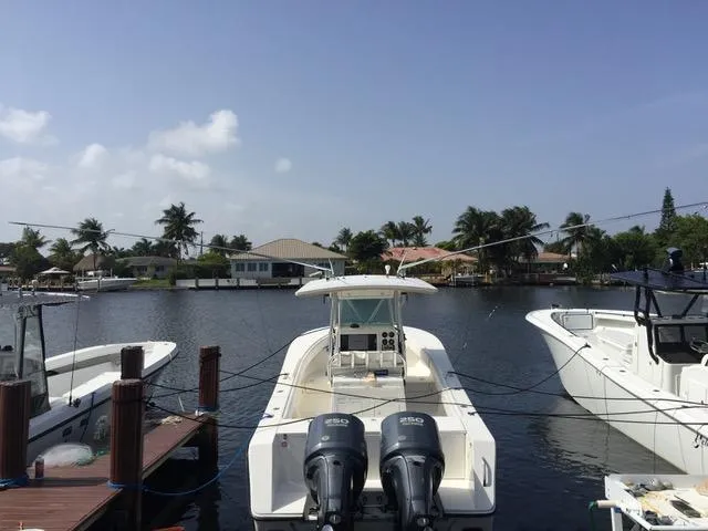 Slide: The Image of 2002 Regulator 32 Forward Seating boat docked in a scenic waterfront area. - 23
