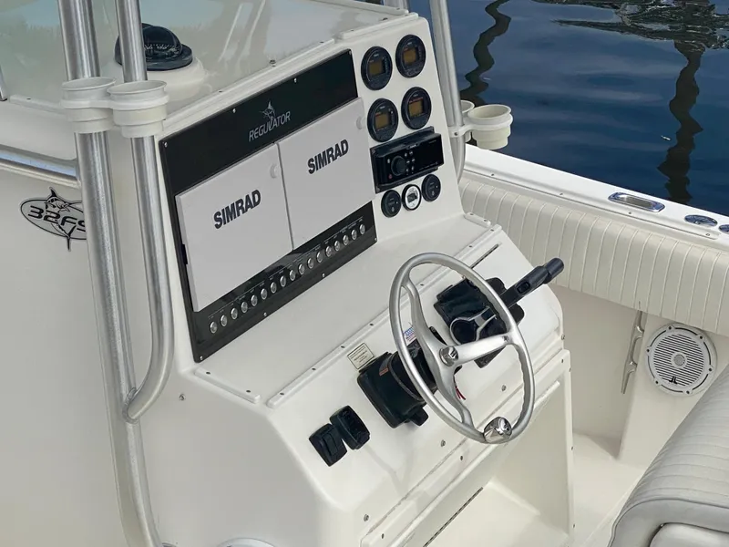 Slide: The Image of 2002 Regulator 32 Forward Seating boat dashboard with Simrad electronics and steering wheel. - 9
