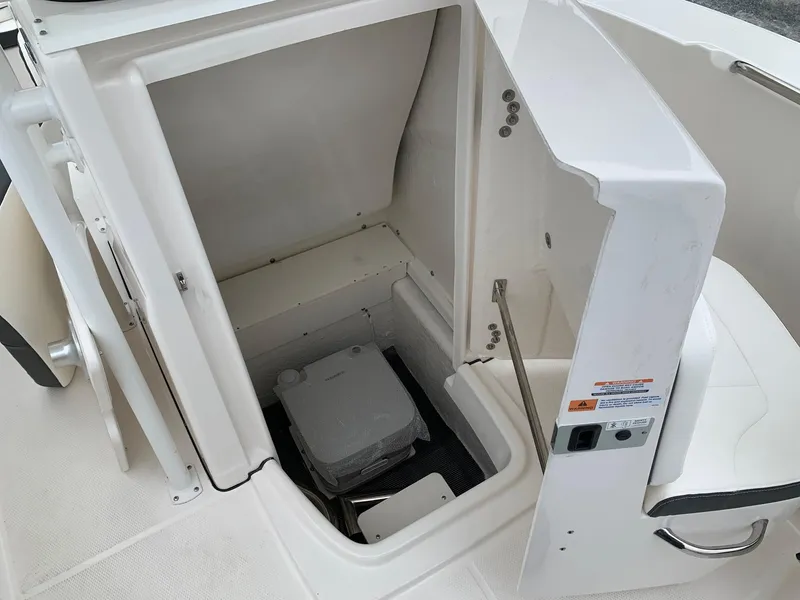 Slide: The Image of 2026 Robalo R200 Center Console boat storage compartment with portable toilet. - 12