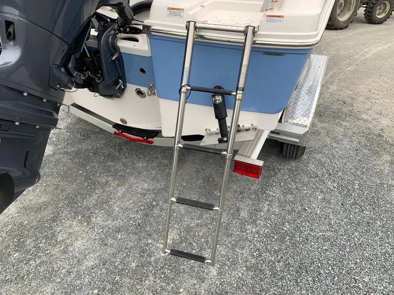 Slide: The Image of 2026 Robalo R200 Center Console boat with ladder and outboard motor on trailer. - 14