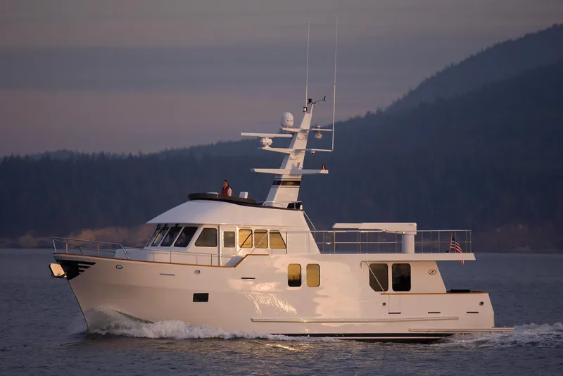 Slide: The Image of Luxury Northern Marine 64 yacht cruising on serene waters at sunset, 2027 model. - 9