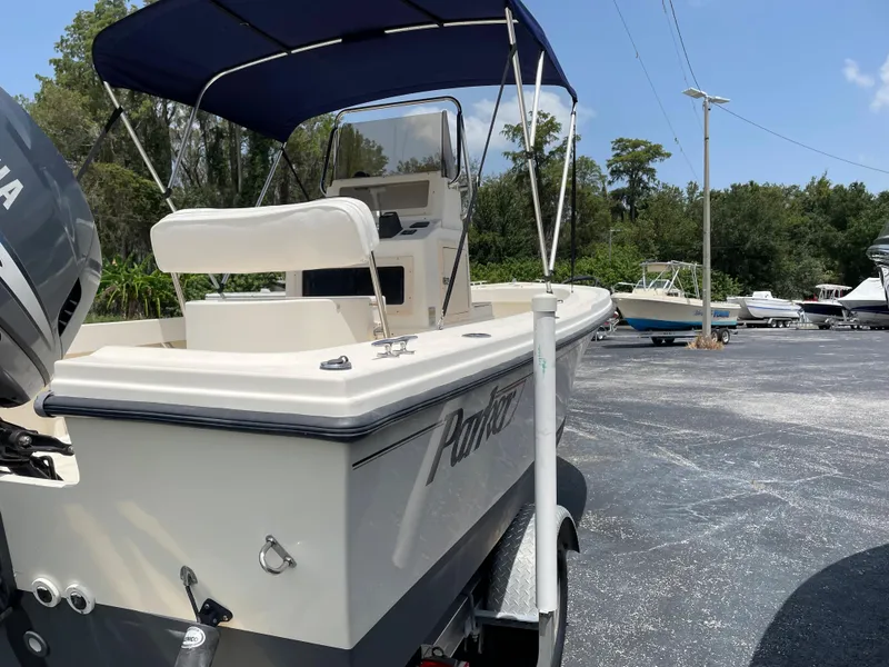 Slide: The Image of 2004 Parker 1801 Center Console boat with blue canopy in a parking lot. - 2