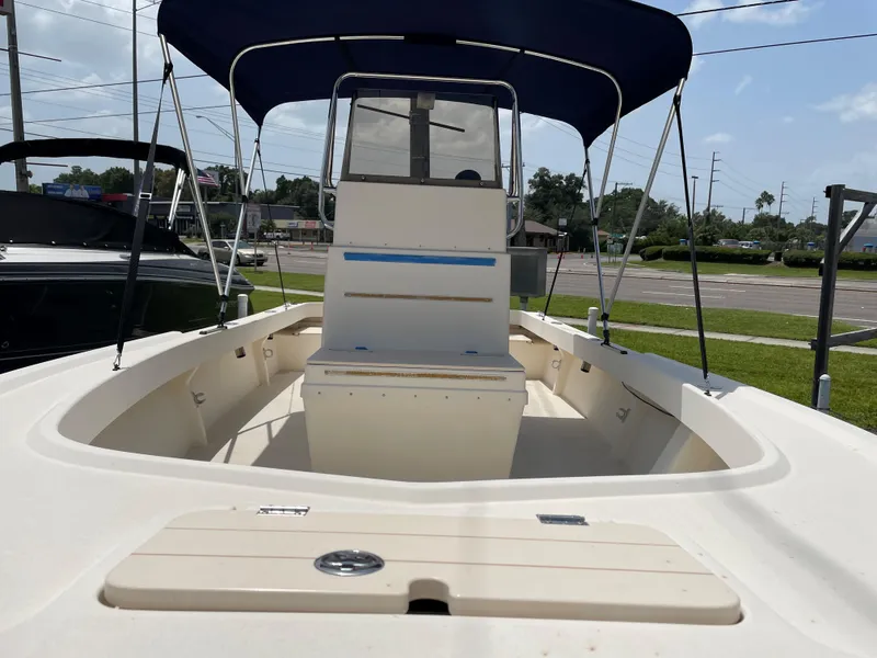 Slide: The Image of 2004 Parker 1801 Center Console boat with blue canopy, docked on a sunny day. - 6