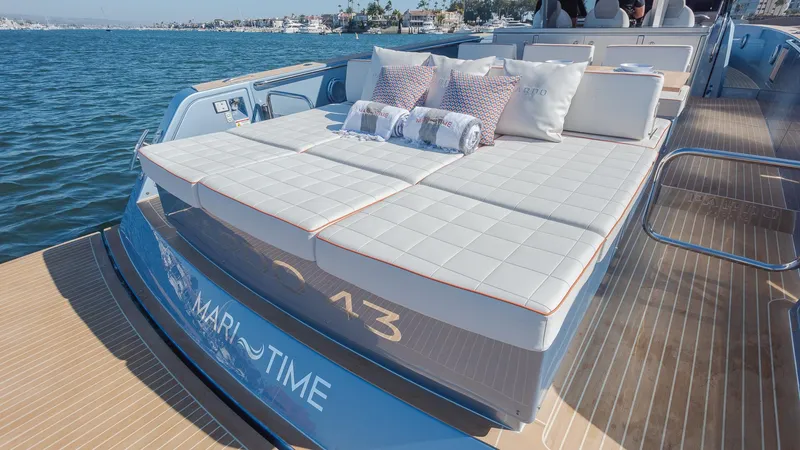 Slide: The Image of 2022 Pardo Yachts 43 luxury deck with sunbed and cushions, docked on calm water. - 13