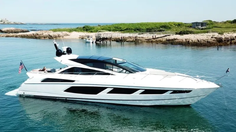Slide: The Image of 2018 Sunseeker Predator 68 yacht cruising in a serene coastal area. - 0