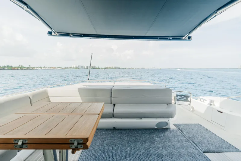 Slide: The Image of 2018 Sunseeker Predator 68 yacht, rear deck with seating and table, ocean view. - 15