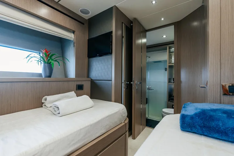 Slide: The Image of Sunseeker Predator 68 2018 yacht cabin with twin beds, modern decor, and en-suite bathroom. - 36