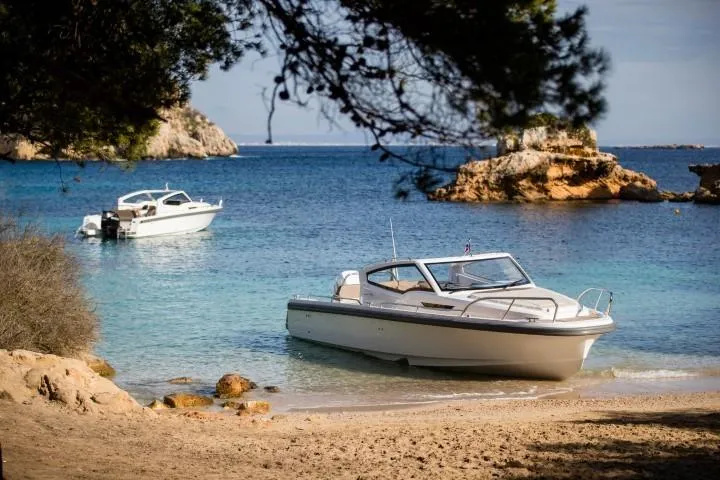 Slide: The Image of 2025 Nimbus W9 boat anchored on a scenic beach with clear blue water. - 22