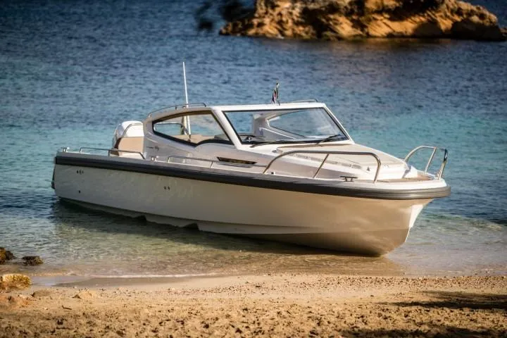 Slide: The Image of 2025 Nimbus W9 boat docked on a sandy beach with clear blue water. - 23