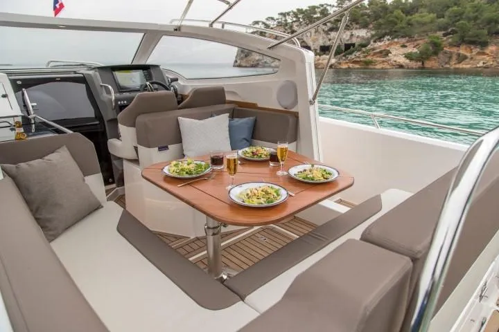 Slide: The Image of Luxurious 2025 Nimbus W9 yacht interior with dining setup, docked in scenic waters. - 40