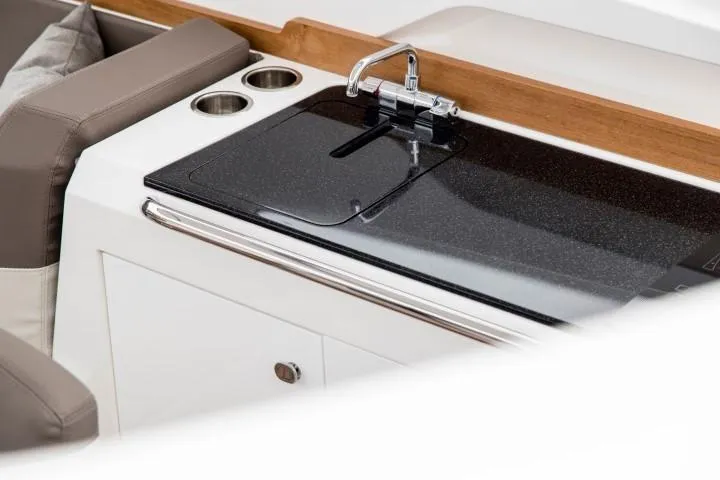 Slide: The Image of Modern kitchenette on Nimbus W9 boat, featuring sleek black countertop and stainless steel faucet. - 34