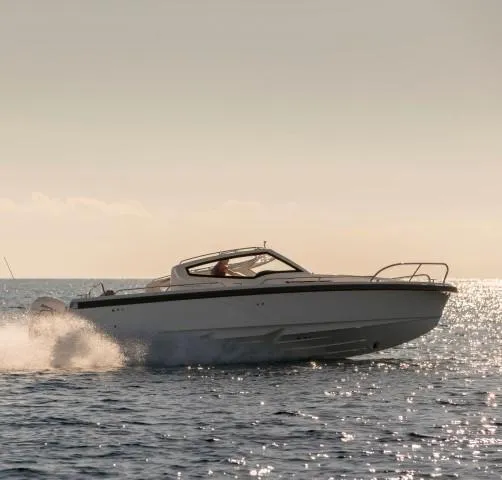 Slide: The Image of 2025 Nimbus W9 boat cruising on open water at sunset. - 15