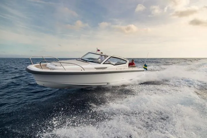 Slide: The Image of Nimbus W9 2025 model boat cruising on open water at sunset. - 27