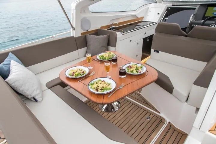 Slide: The Image of Dining area on the 2025 Nimbus W9 yacht with meals and drinks on the table. - 30