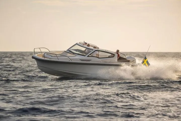 Slide: The Image of Nimbus W9 2025 model boat cruising on open water at sunset. - 39