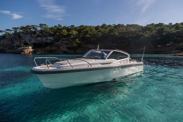 Slide: The Image of Nimbus W9 2025 boat cruising in clear blue waters near a forested coastline. - 14