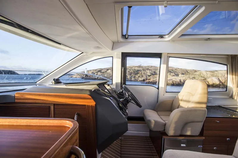 Slide: The Image of Interior of 2025 Nimbus 305 Coupe boat with modern design and panoramic windows. - 2