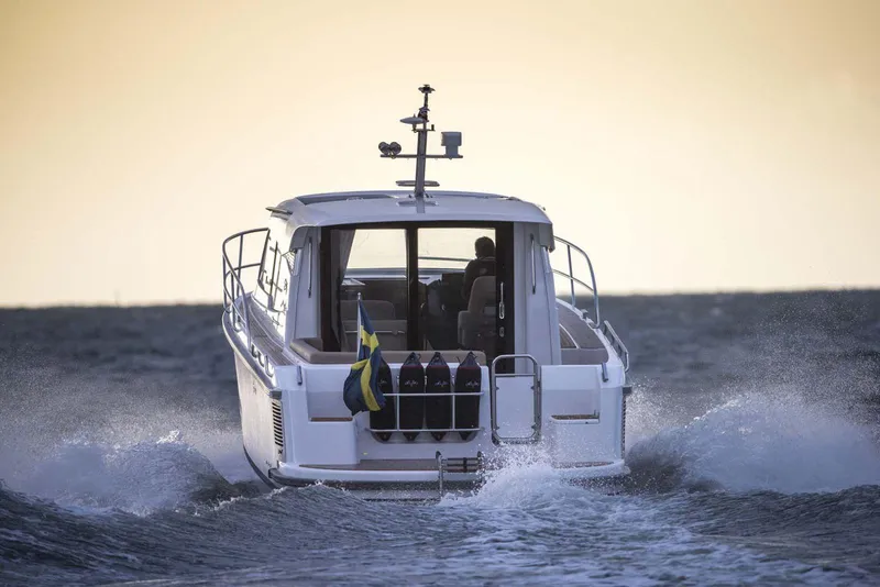 Slide: The Image of 2024 Nimbus 305 Coupe cruising on open water at sunset. - 1