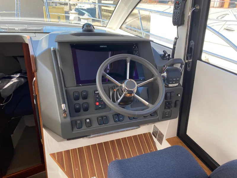 Slide: The Image of 2024 Nimbus 305 Coupe helm station with modern navigation controls and steering wheel. - 3