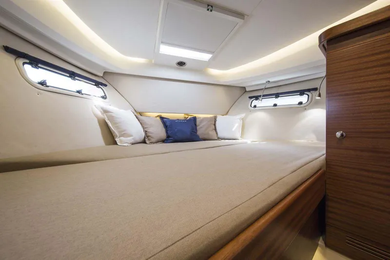 Slide: The Image of Luxurious cabin interior of 2024 Nimbus 305 Coupe with cozy bedding and ambient lighting. - 9