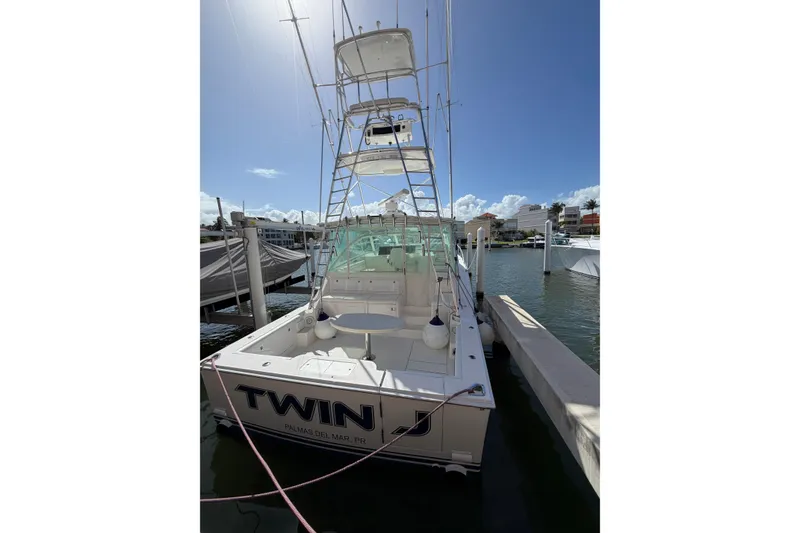 Slide: The Image of 2003 Cabo 45 Express boat docked at marina under clear blue sky. - 3