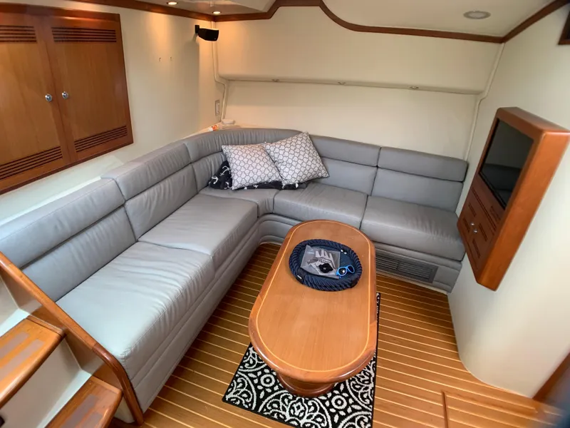 Slide: The Image of Interior of a 2003 Cabo 45 Express yacht with gray sofa and wooden table. - 8
