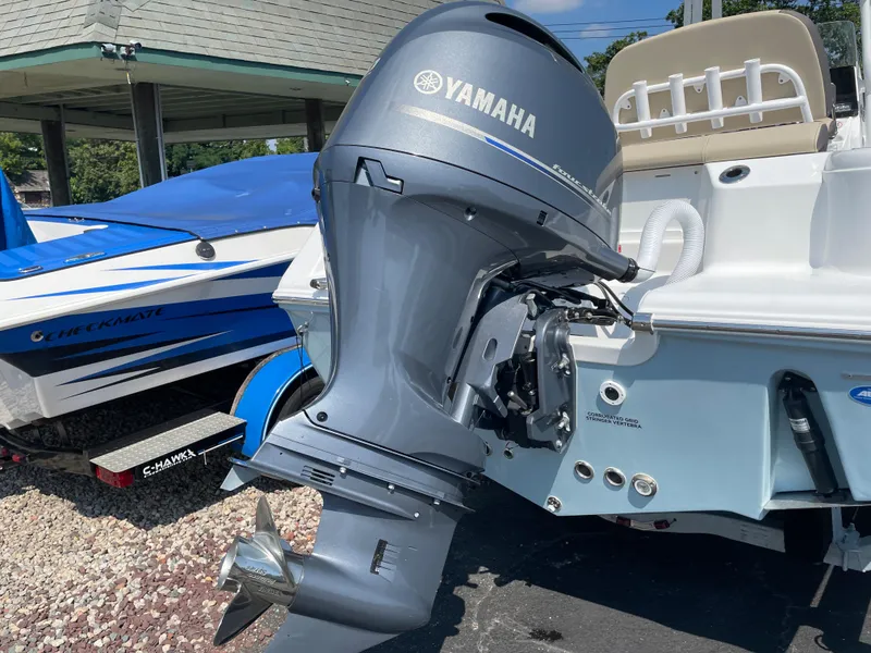 Slide: The Image of 2022 Tidewater 220 CC Adventure boat with Yamaha outboard motor, parked outdoors. - 1