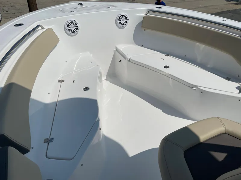 Slide: The Image of 2022 Tidewater 220 CC Adventure boat interior with beige seating and white deck. - 11