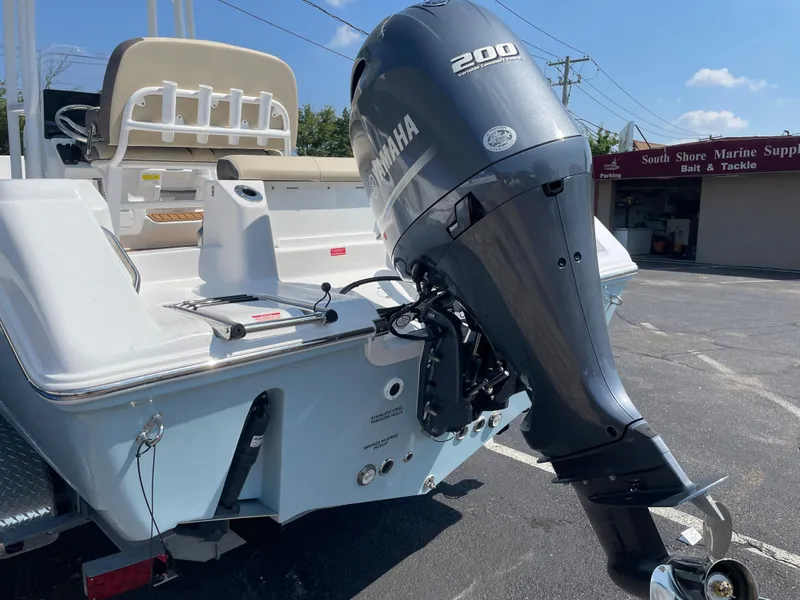 Slide: The Image of 2022 Tidewater 220 CC Adventure boat with Yamaha 200 outboard motor in a parking lot. - 2