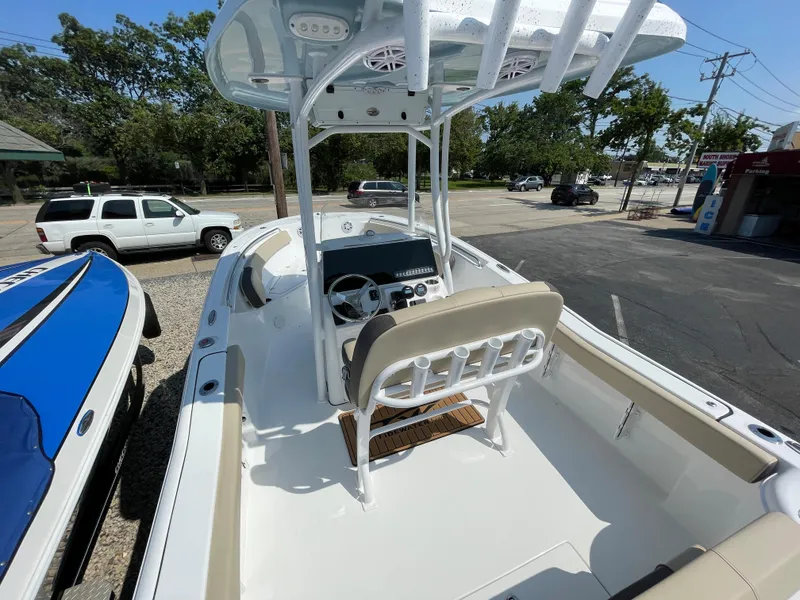Slide: The Image of 2022 Tidewater 220 CC Adventure boat with center console and seating, parked outdoors. - 3