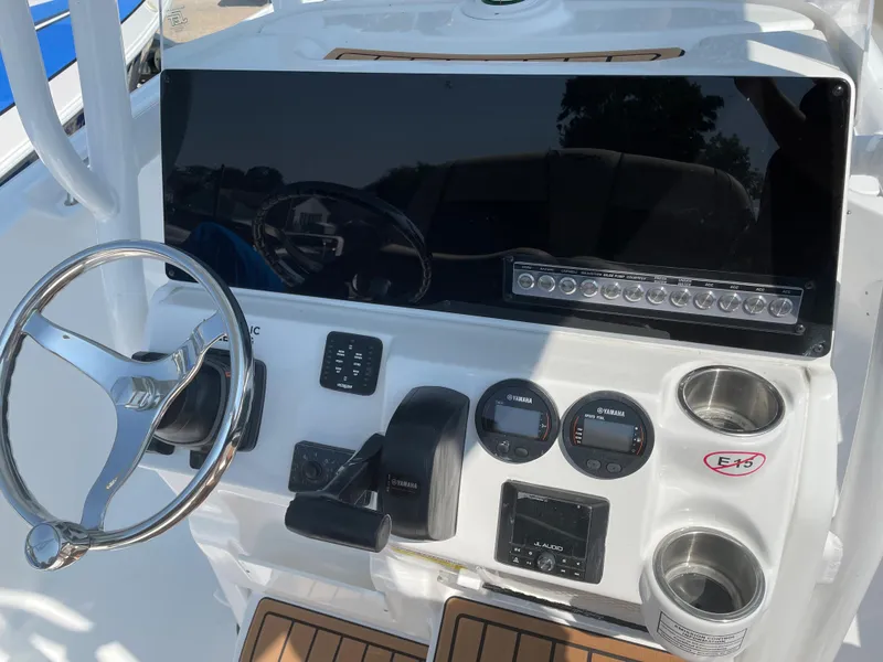 Slide: The Image of 2022 Tidewater 220 CC Adventure boat dashboard with steering wheel and control panel. - 9