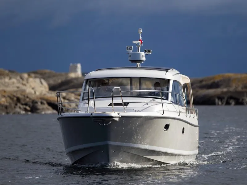 Slide: The Image of 2025 Nimbus 365 Coupe cruising on open water with rocky shoreline in the background. - 3
