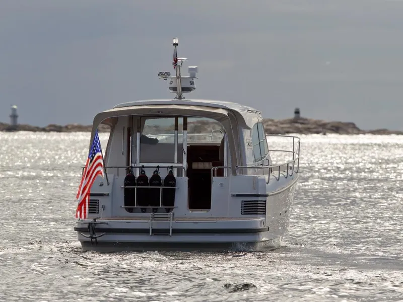 Slide: The Image of Nimbus 365 Coupe 2025 boat cruising on a sunny day with an American flag. - 2