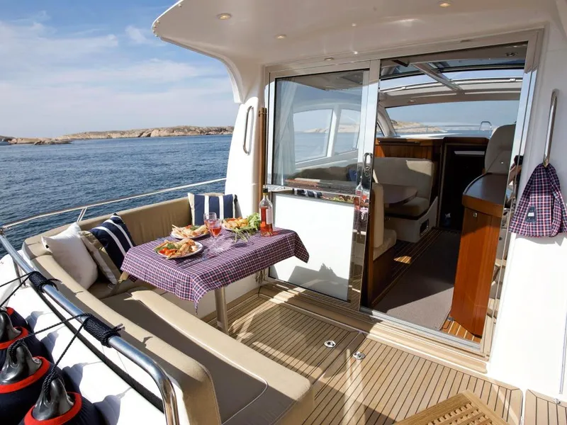 Slide: The Image of Luxurious 2025 Nimbus 365 Coupe yacht with outdoor dining area and ocean view. - 4