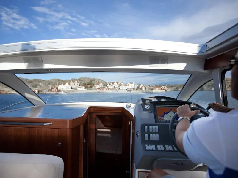 Slide: The Image of Interior view of 2025 Nimbus 365 Coupe boat with scenic coastal background. - 9