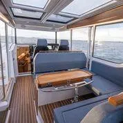 Slide: The Image of Interior of 2025 Nimbus C11 boat with modern seating and panoramic windows. - 2