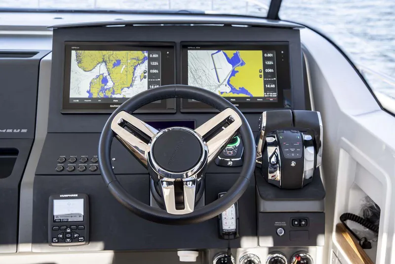 Slide: The Image of Nimbus T11 2025 boat dashboard with dual navigation screens and steering wheel. - 3