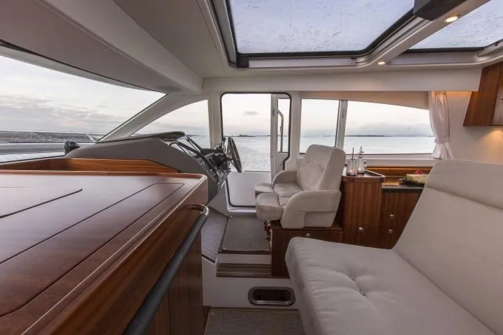 Slide: The Image of Interior of 2025 Nimbus 405 Coupé yacht with luxurious seating and panoramic windows. - 10