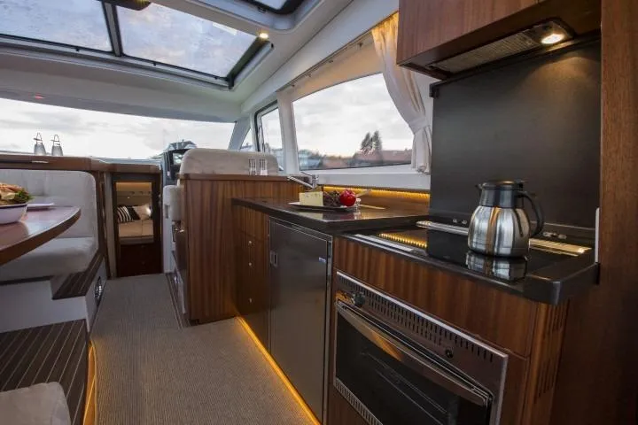 Slide: The Image of Luxurious interior of 2025 Nimbus 405 Coupé yacht with modern kitchen and dining area. - 11