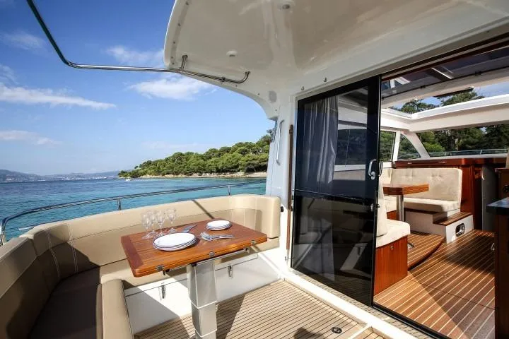 Slide: The Image of 2025 Nimbus 405 Coupé luxury yacht with elegant dining area and scenic ocean view. - 7