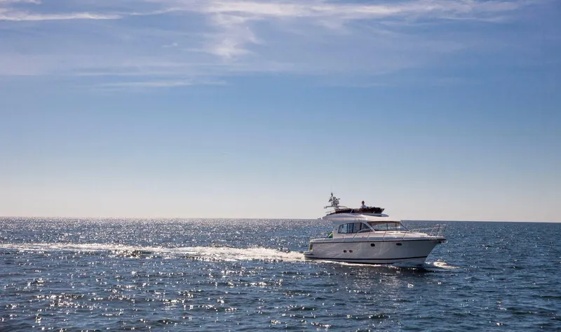 Slide: The Image of 2025 Nimbus 405 Flybridge cruising on a sunny day in open waters. - 1