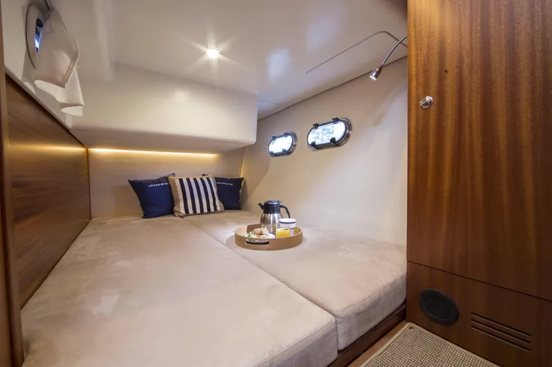 Slide: The Image of Luxurious cabin interior of 2025 Nimbus 405 Flybridge with cozy bedding and porthole windows. - 12