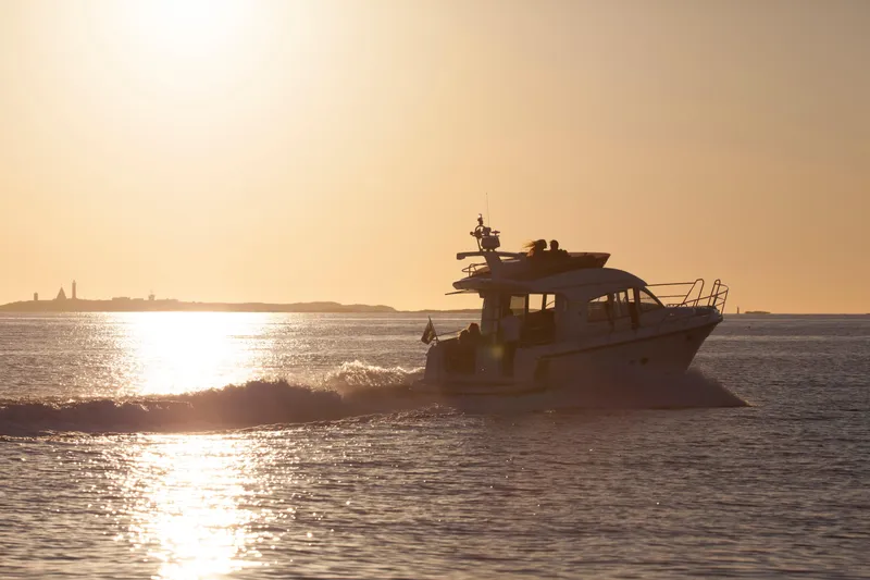 Slide: The Image of Nimbus 405 Flybridge 2025 yacht cruising at sunset on open water. - 2