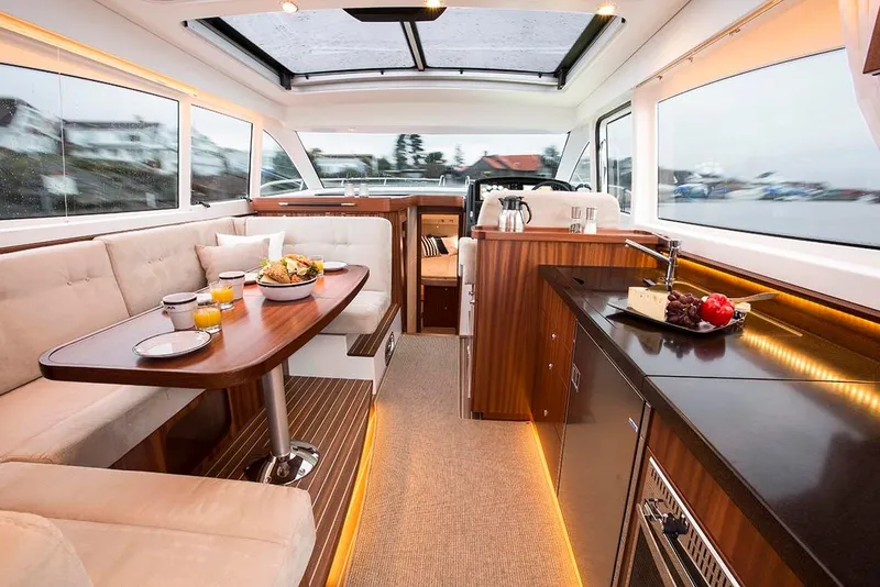 Slide: The Image of Luxurious interior of the 2025 Nimbus 405 Flybridge yacht with dining and kitchen area. - 7