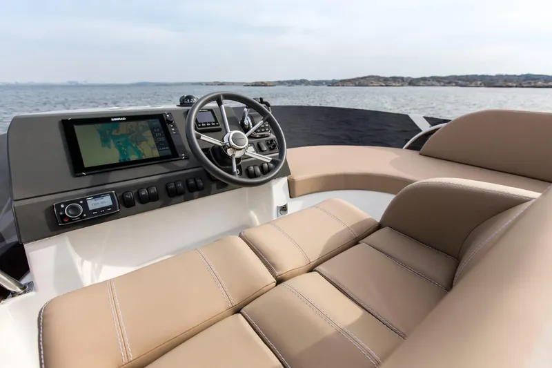 Slide: The Image of 2025 Nimbus 405 Flybridge helm with beige seating and navigation system. - 5
