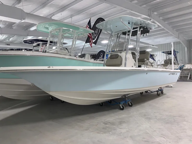 Slide: The Image of 2024 Key West 230 Bay Reef boat displayed in a showroom. - 2