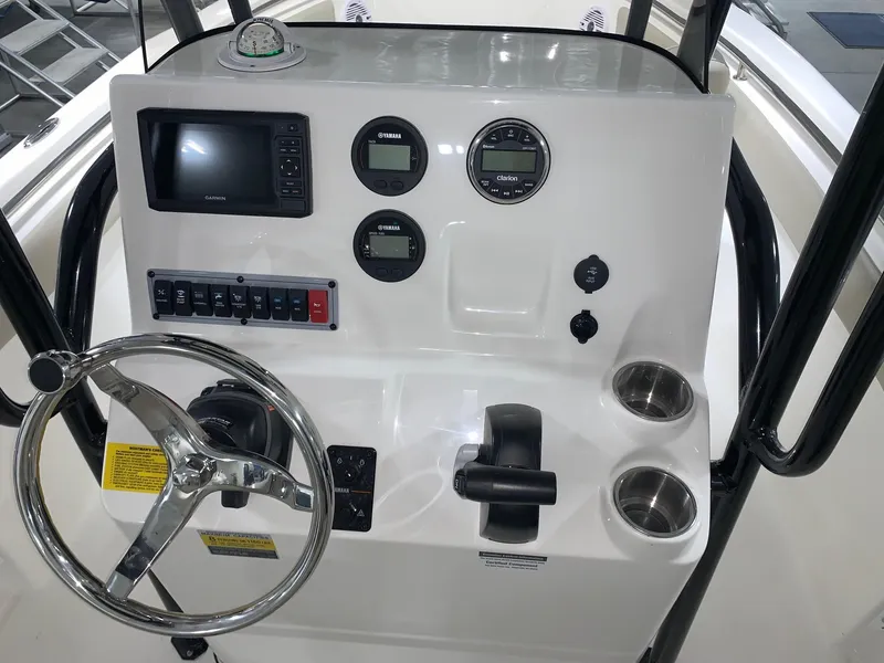Slide: The Image of 2024 Key West 203 FS boat console with steering wheel, gauges, and controls. - 16