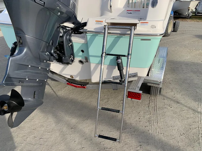 Slide: The Image of 2024 Robalo R202 Explorer boat stern with outboard motor and ladder. - 17