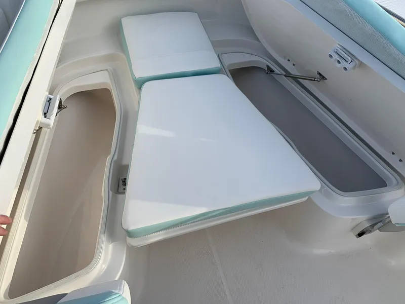Slide: The Image of 2024 Robalo R202 Explorer boat interior with storage compartments and cushioned seating. - 11